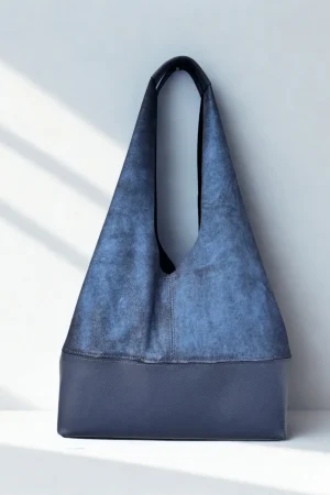 Close-up of blue handmade suede leather shoulder bag featuring premium zipper detail and artisan craftsmanship