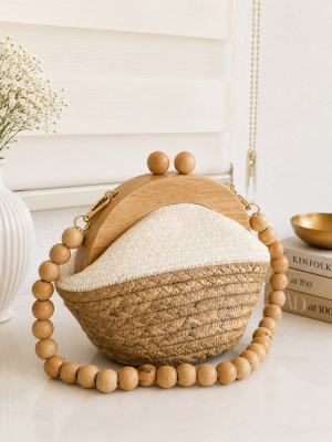Handmade straw clutch bag with wooden frame and beaded handle in natural beige color